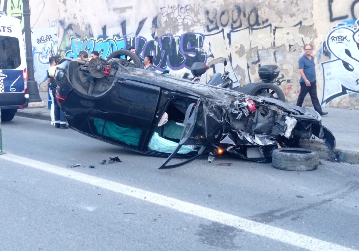 El coche volcado tras colisionar contra las farolas y el pretil del puente.