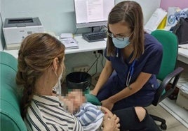 Una sanitaria atiende a una madre con su bebé en una consulta de lactancia materna.