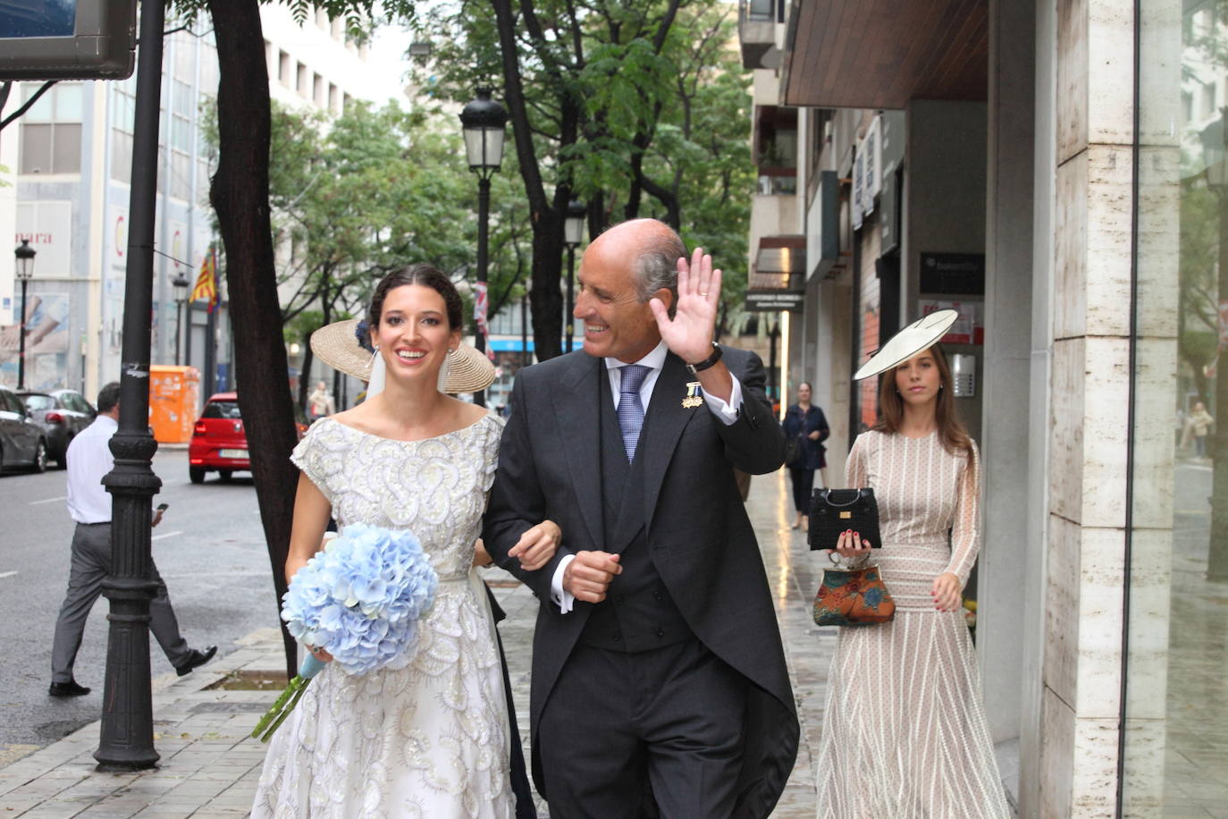 Isa Camps llega a la iglesia acompañada de su padre, Francisco Camps, que responde con un saludo a los aplausos.