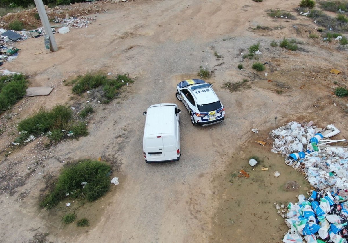 Un vehículo de la Policía Local. en las inmediaciones de un vertedero ilegal a vista de dron.