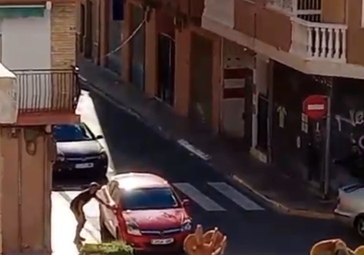 La víctima se esconde detrás de un coche tras ser tiroteada en una calle de Manises.