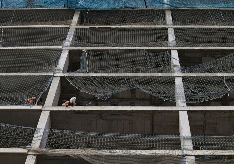 Dos obreros trabajan en la construcción de un edificio en Valencia.