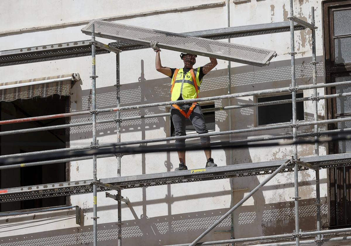 Un obrero de la construcción trabaja en un andamio.