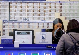 Una mujer compra un décimo en una administración de Lotería.