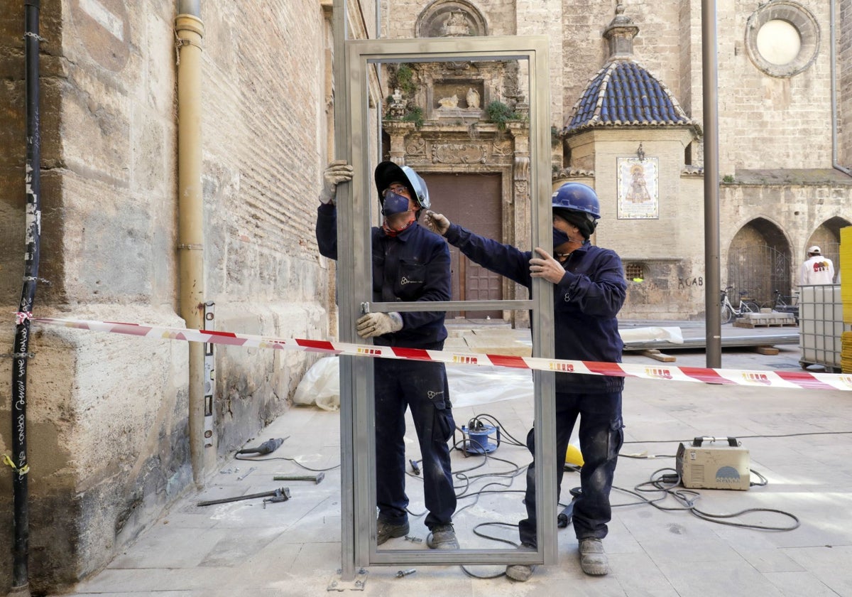 Dos trabajadores colocan un andamio en el centro de Valencia.