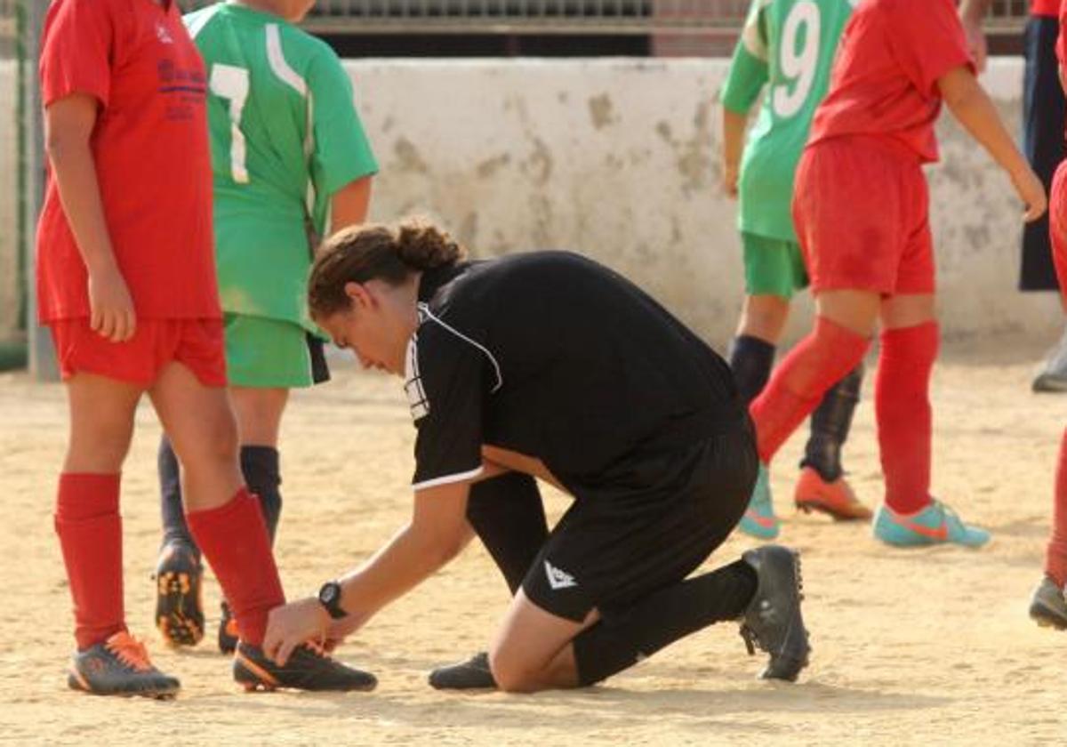 Un árbitro ata los cordones a un jugador en una imagen de archivo.