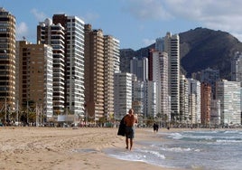 Un hombre pasea por la playa de Benidorm.