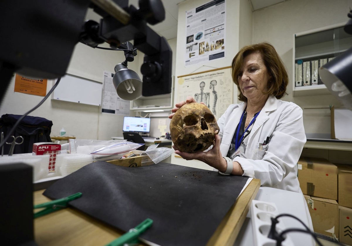 La directora del Instituto de Medicina Legal de Valencia, Elvira Garrido-Lesteche, sostiene un cráneo humano en el departamento de antropología forense.