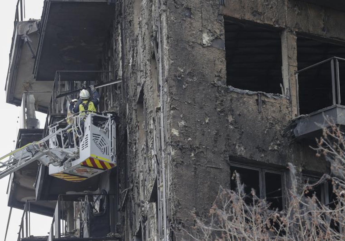 Un bombero inspecciona una balcón destruido por el fuego.