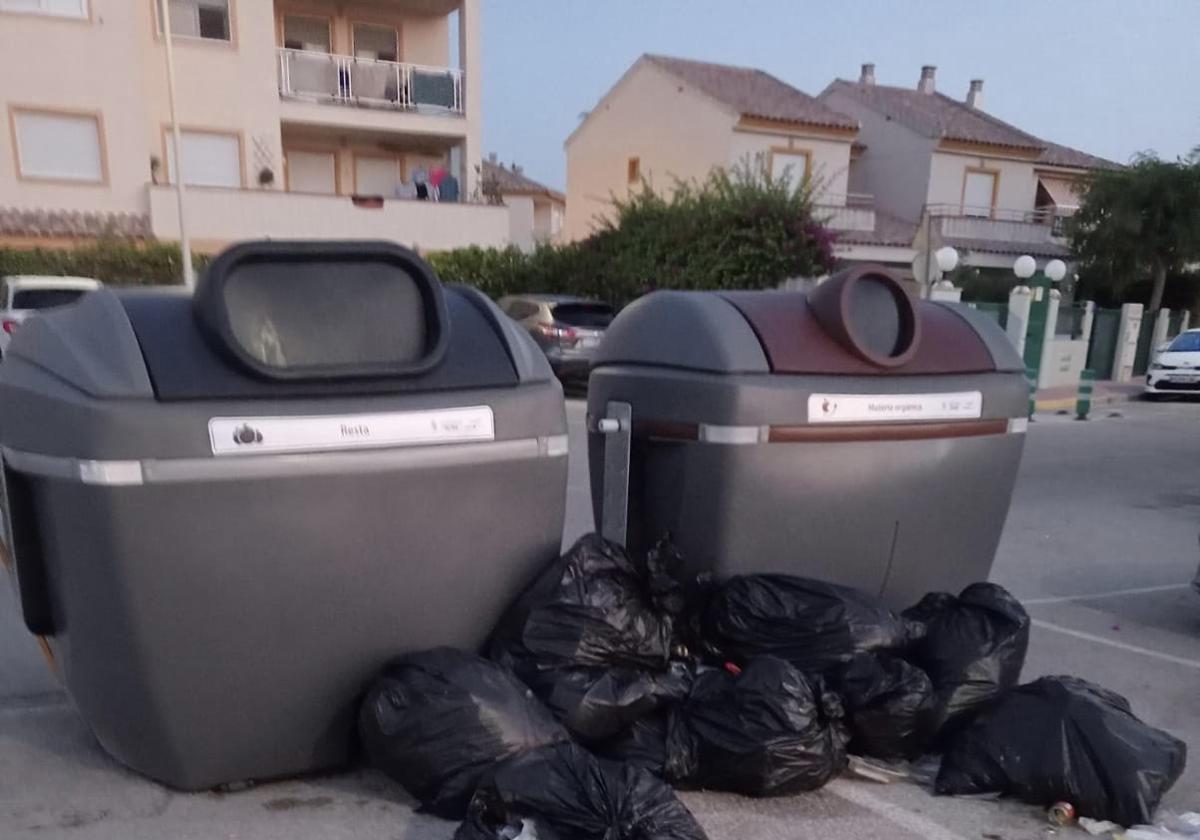 Bolsas de basura fuera de los contenedores.