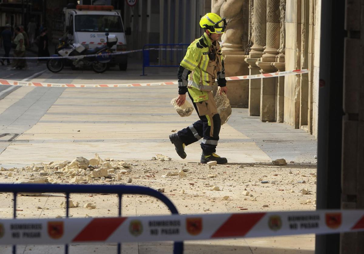 Un bombero retira cascotes caídos.