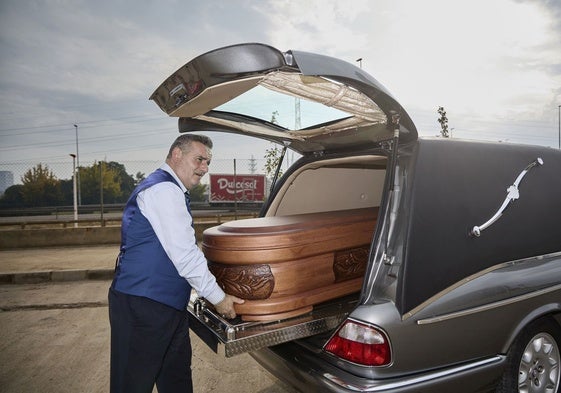 Javier Flores, conductor de la funeraria La Esperanza, traslada un féretro en Paiporta.