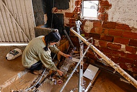 Una joven entre los desperfectos de su casa en Sedaví.