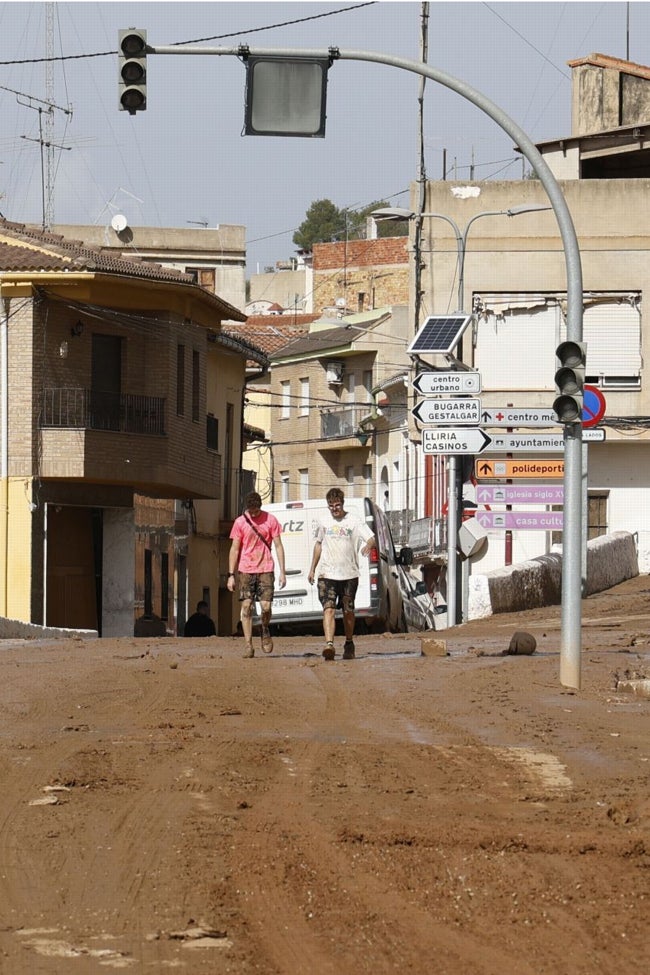 Dos jóvenes voluntarios en una calle de Pedralba.