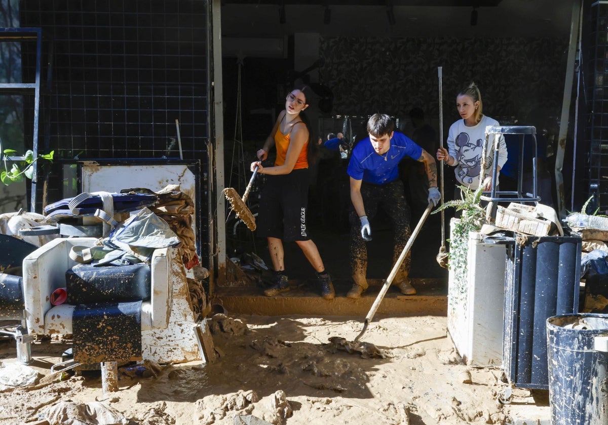 Los vecinos de Alfafar retiran el barro de uno de los bajos.