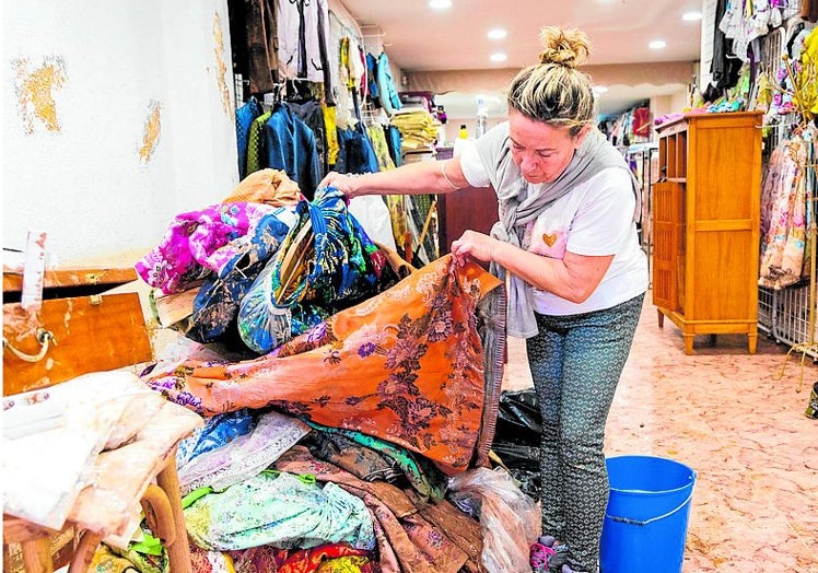 Andrea, la propietaria de una tienda de indumentaria valenciana, revisa las telas.