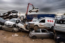 Una grúa recoge los coches dañados por la DANA en Paiporta.