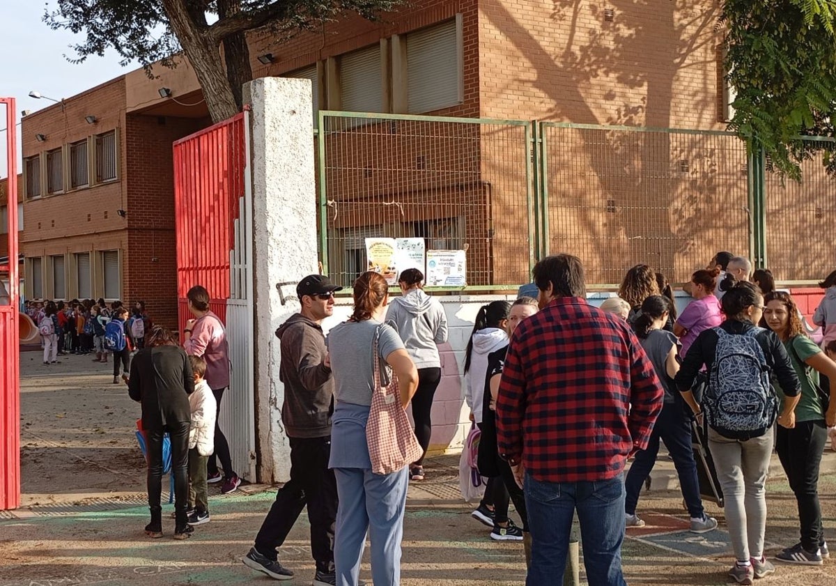 Imagen principal - Familiares de los alumnos del CEIP Castellar, en la puerta del centro.