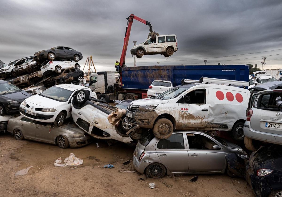 Una grúa recoge los coches dañados por la DANA en Paiporta.