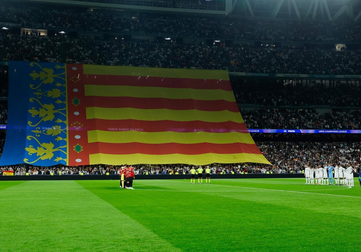 Senyera gigante desplegada durante el minuto de silencio previo al Real Madrid-Milan.