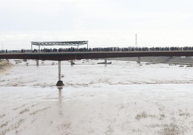 Cientos de voluntarios cruzan el puente hacia l'Horta Sud.