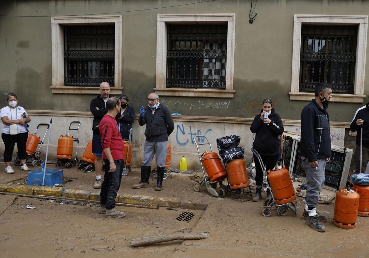 Una cola de vecinos en Benetússer, esperando el camión del butano.