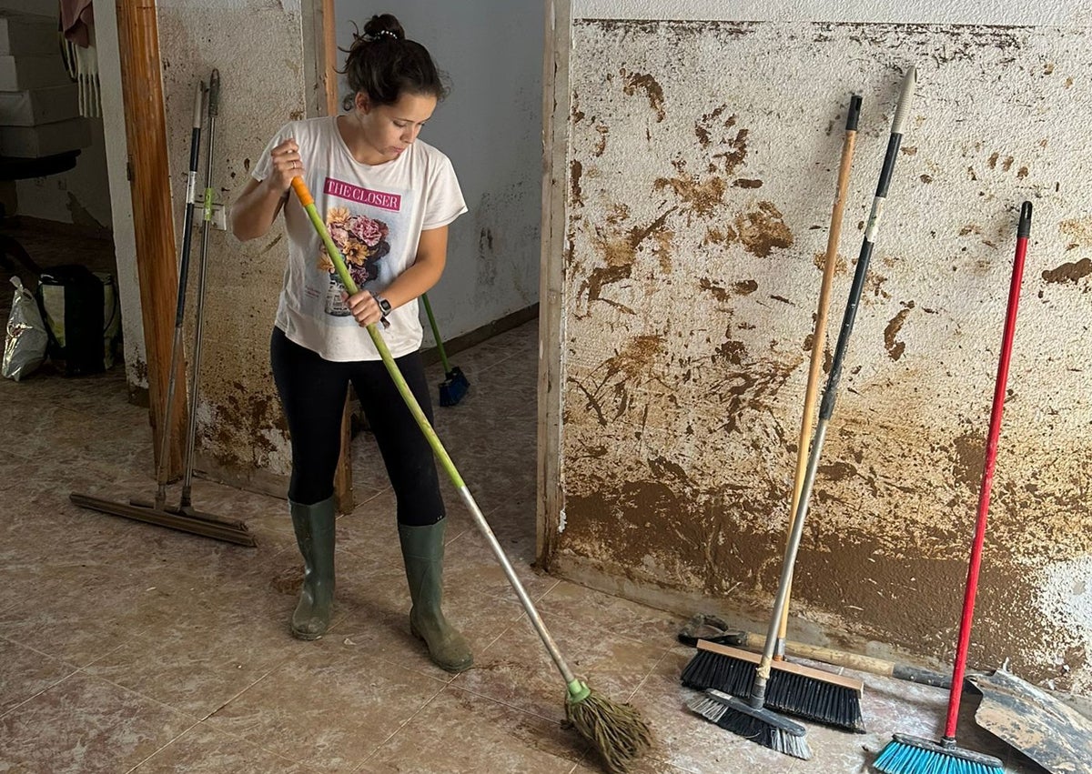 Imagen secundaria 1 - Carles y su novia Fátima, limpiando su casa de Benetússer de donde han tenido que irse por el barro.