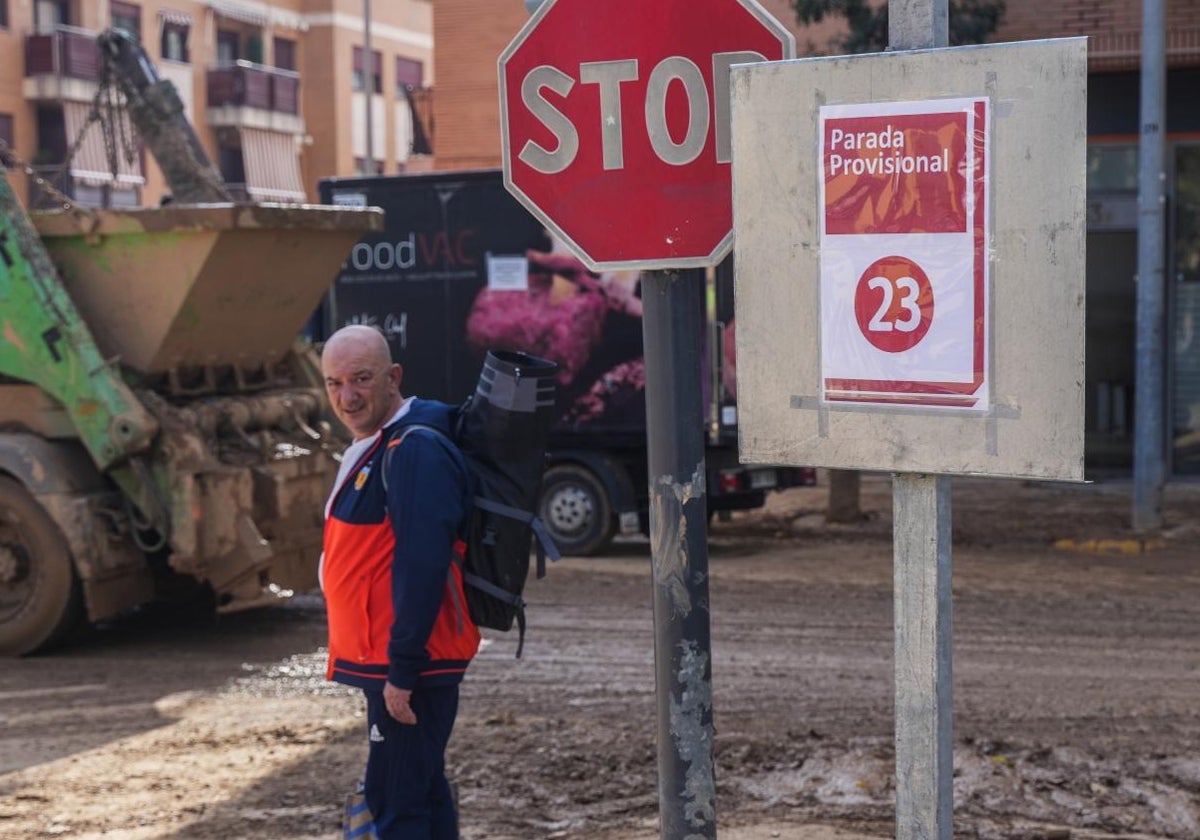 Un hombre, junto a una parada provisional de la línea 23 en Sedaví.