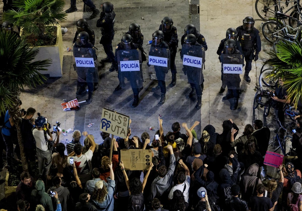 Un grupo de manifestantes increpan e insultan a los policías.