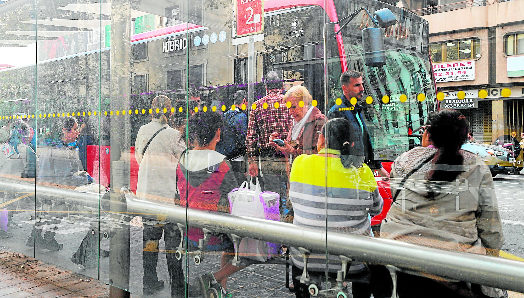 Usuarios de la EMT esperan su autobús en el intercambiador de la calle Xàtiva.