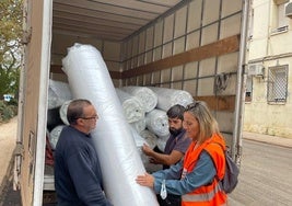 La edil Paula Llobet, con los transportistas de colchones y camas.