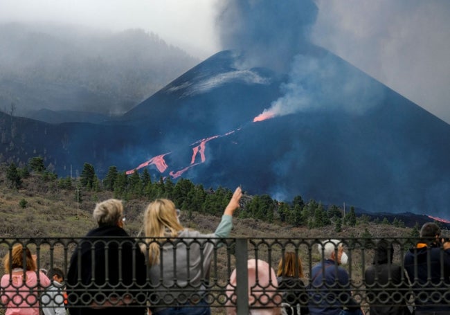 Varias personas observan las coladas de lava en La Palma.