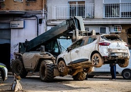 Una grúa retira un vehículo dañado por el temporal.