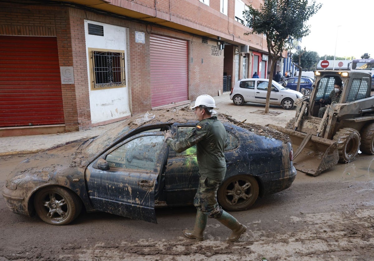 Varios militares recogen coches en una calle de Catarroja.