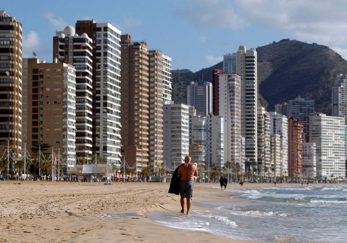 Una persona pasea por la playa de Benidorm. Imagen de archivo.