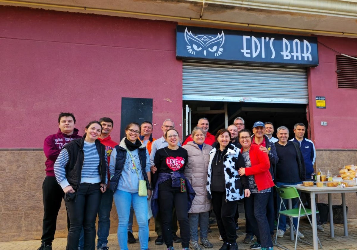 Un equipo de voluntarios de Madrid posan en la puerta del Edi's Bar de Catarroja.