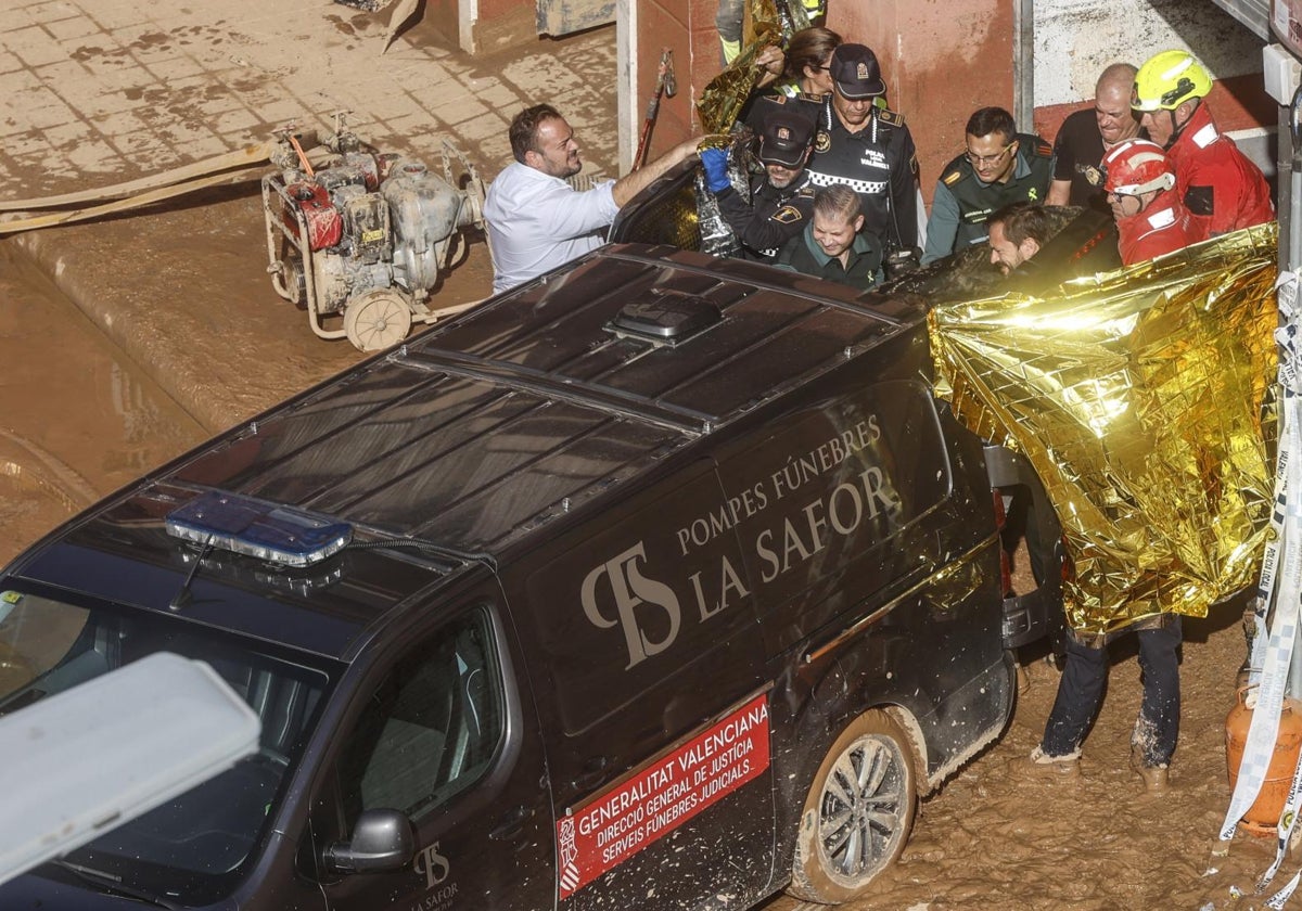 Los servicios de emergencia introducen en un furgón uno de los cadáveres hallados en un garaje de La Torre.