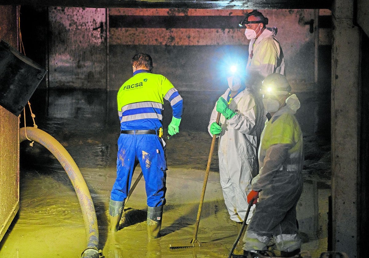 Trabajadores de la Diputación retiran el lodo de un aparcamiento en Massanassa.