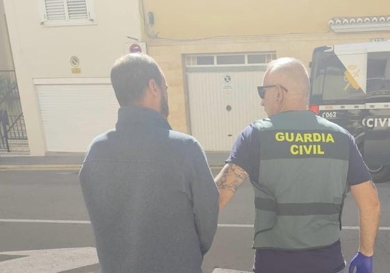 Un agente de la Guardia Civil detiene a uno de los cabecillas.