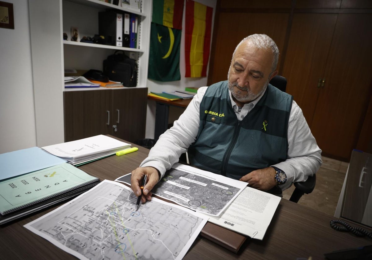 El comandante Julián Martínez examina el mapa con círculos que ubican los lugares donde hallaron los cuerpos.