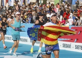 Un corredor llega a la recta final desplegando la bandera de la Comunitat.