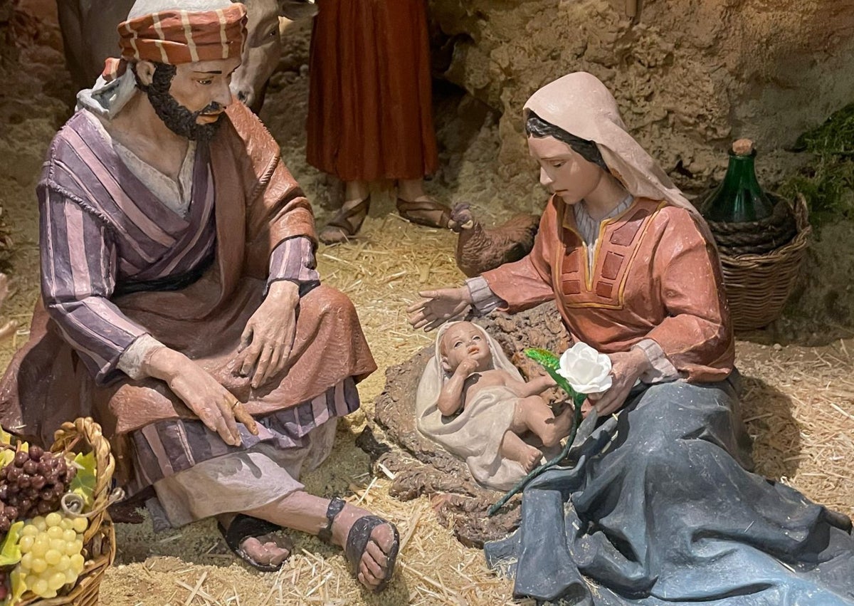 Imagen secundaria 1 - Voluntario de la DANA junto a los Reyes de Oriente, pesebre con la rosa blanca y palas apoyadas en un escenario del belén.