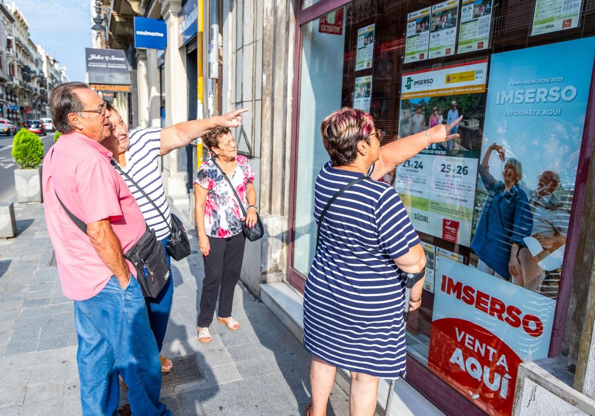 Pensionistas viendo anuncio del Imserso en una imagen de archivo.