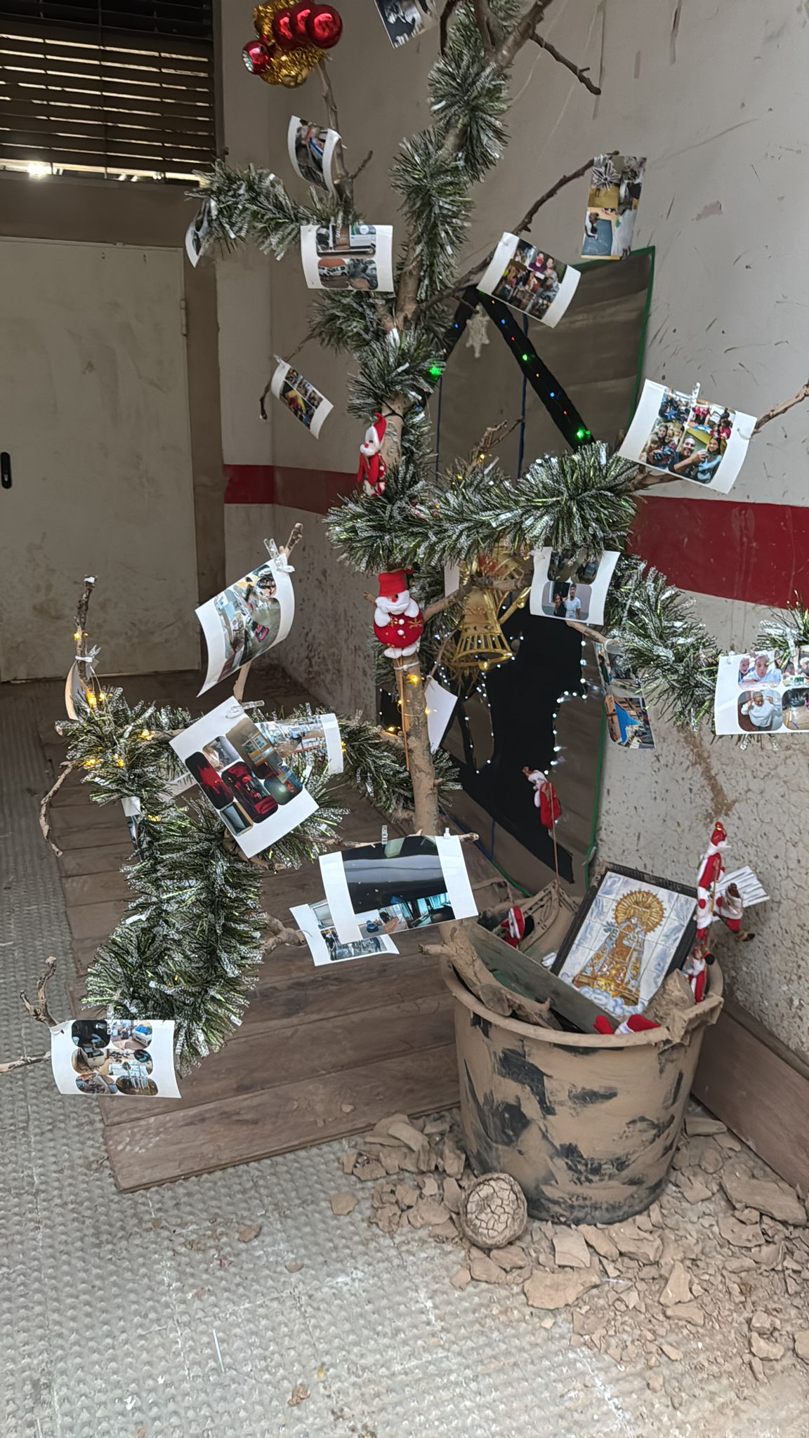 Imagen secundaria 2 - Un árbol arrancado por la dana con fotos de vecinos de Guadassuar, símbolo de unión tras la tragedia