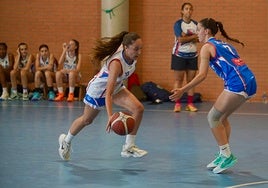 Dos jugadoras de baloncesto tratan de disputarse el balón