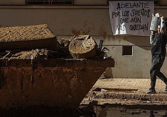 Un ciudadano retira escombros en Catarroja.