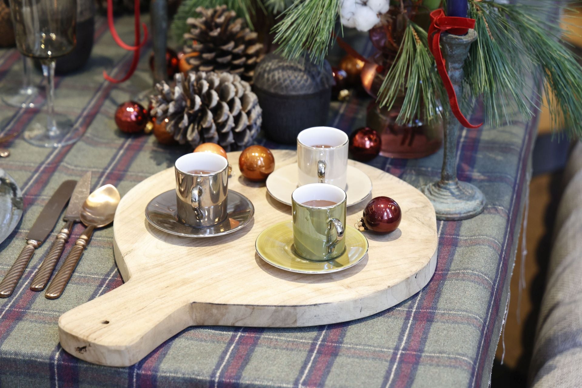 Tazas de café para la mousse de chocolate sobre una tabla de madera decorada con bolas.