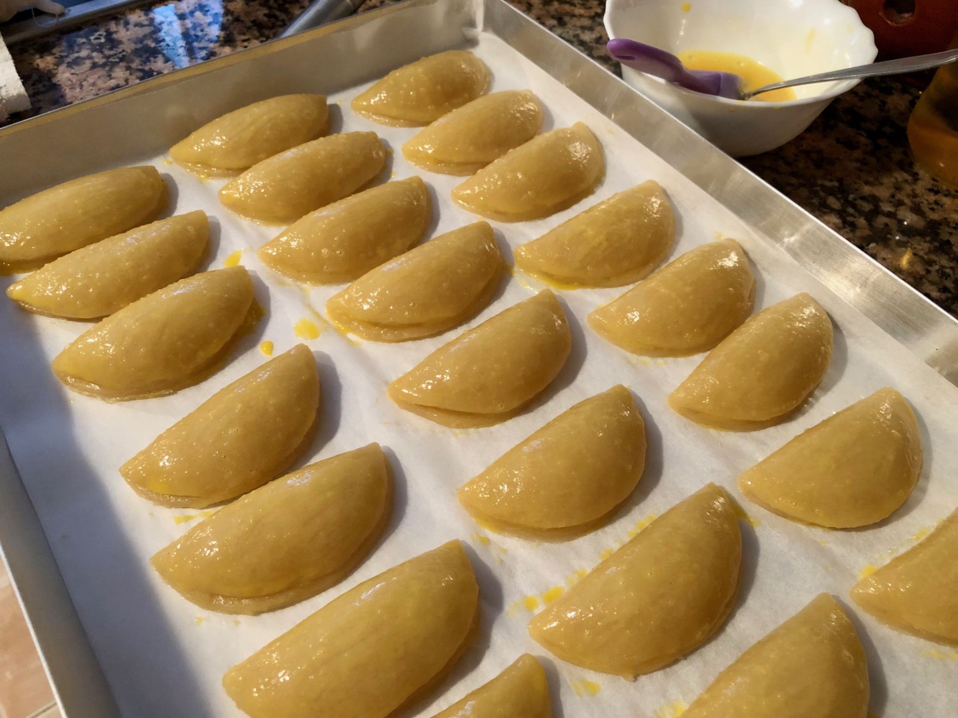 Imagen secundaria 1 - Las bandejas con los pastissets de aguardiente (azúcar y canela) y mistela (pintados con huevo batido). Y ya sobre la mesa.