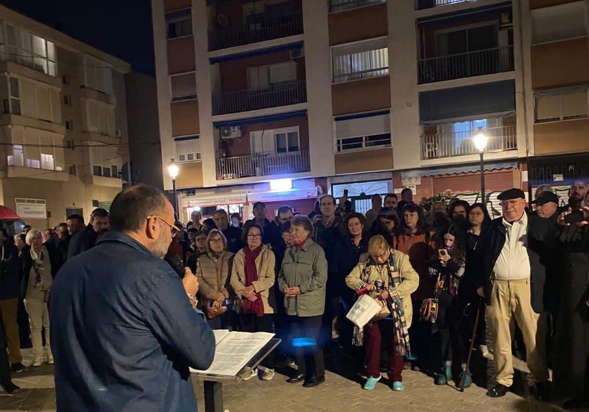 Imagen principal - Minuto de silencio que organizó la asociación de Patraix en memoria de las víctimas de la dana y cartel de agradecimiento a los voluntarios.