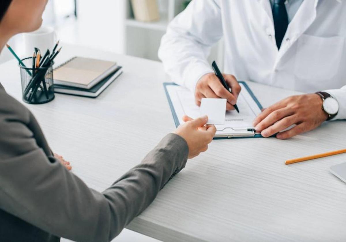 Una mujer consulta a un médico, imagen de archivo.